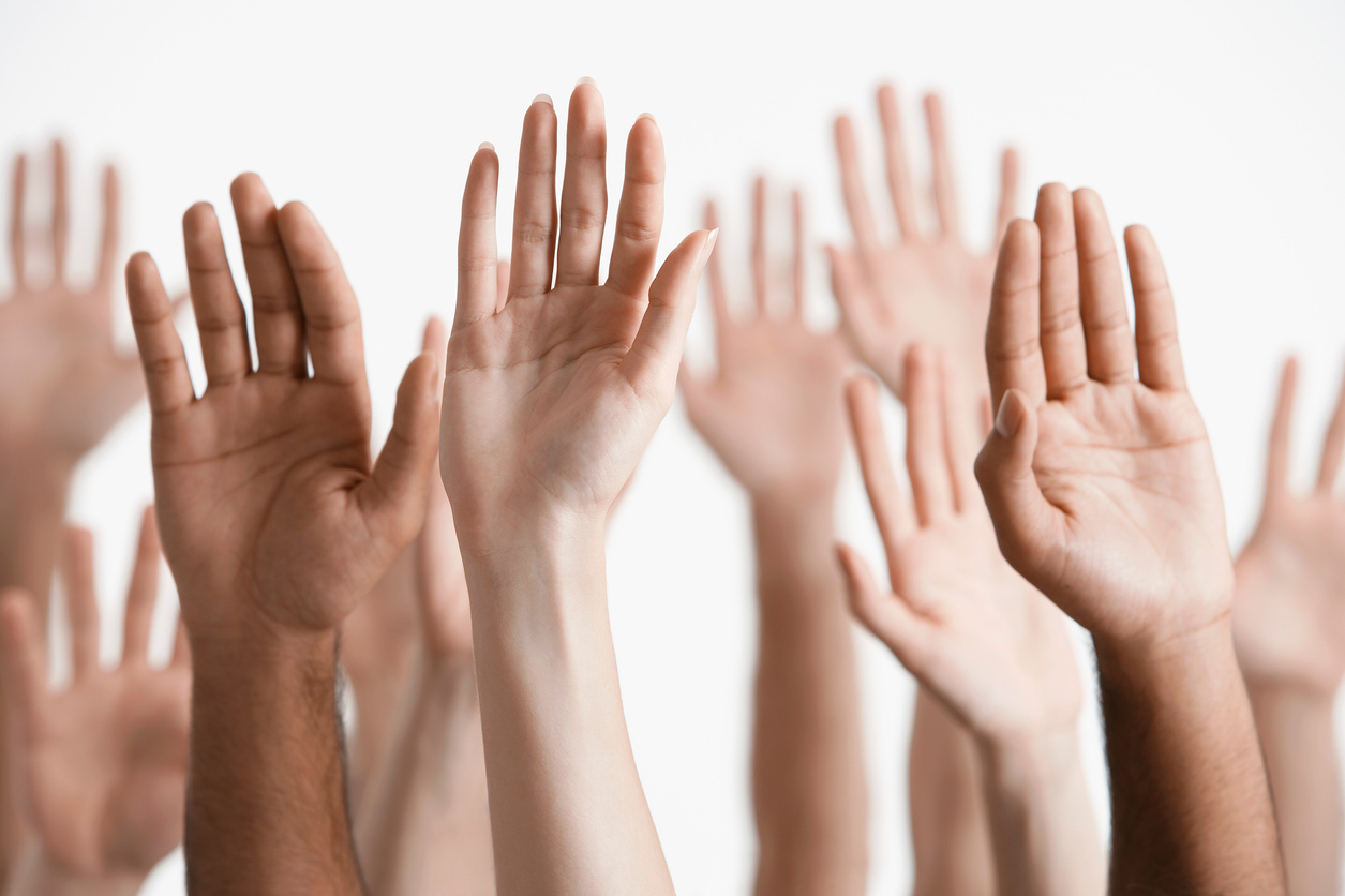 young men and women raising hands close-up of hands